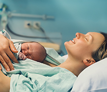 Frau nach der Geburt mit ihrem Baby